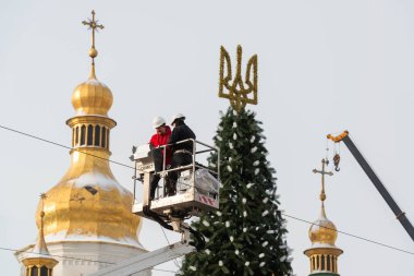 2023-12-05 Kyiv, Ukrayna. Sophia Katedrali 'nin arka planında Noel ağacını süsleyen işçiler.