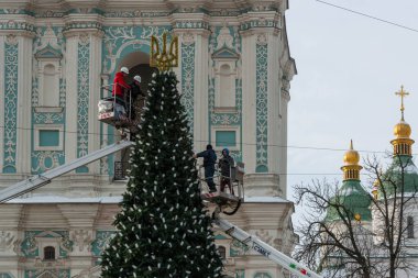 2023-12-05 Kyiv, Ukrayna. Noel ağacına Noel ışıkları asan dekoratörlü iki araba kulesi.