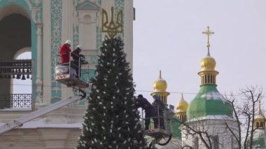 2023-12-05 Kyiv, Ukrayna. Küçük bir Noel ağacının süslemesi müşteriler tarafından şehre bağışlandı. Arka plandaki Aziz Sophia Katedrali..