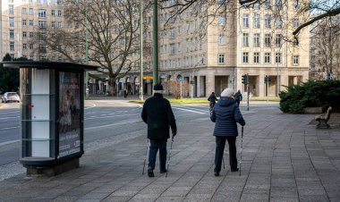 Strausberger Platz, Berlin, Almanya 'da başkentte yürüyen yaşlı çift.