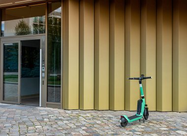 E-scooter Berlin, Almanya 'da bir yerleşim yerinin önüne park edilmiş.