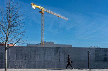 Beton bir duvarın arkasında inşaat vinci, Friedrichshain, Berlin, Almanya