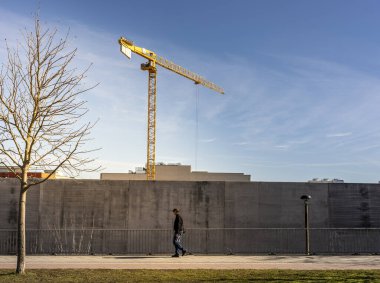 Beton bir duvarın arkasında inşaat vinci, Friedrichshain, Berlin, Almanya