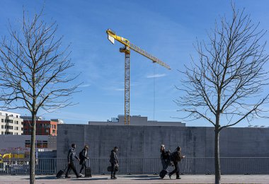 Beton bir duvarın arkasında inşaat vinci, Friedrichshain, Berlin, Almanya