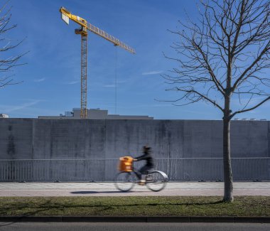 Beton bir duvarın arkasında inşaat vinci, Friedrichshain, Berlin, Almanya