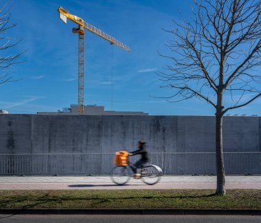 Construction crane behind a concrete wall, Friedrichshain, Berlin, Germany clipart