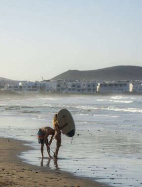 Plajda sörfçüler, Playa Famara, Lanzarote, Kanarya Adaları, İspanya, 2022, Kasım