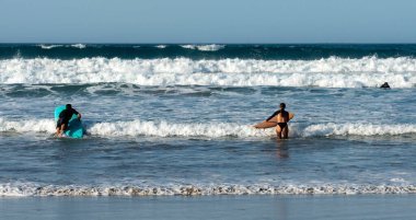 Plajda sörfçüler, Playa Famara, Lanzarote, Kanarya Adaları, İspanya, 2022, Kasım