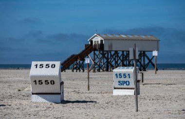 Kuzey Denizi, Sankt-Peter-Ording, Almanya 'nın kuzeyinde Schleswig-Holstein eyâletinde kumsal sandalyeleri ve bilgi tabelaları