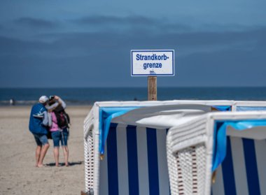 Kuzey Denizi, Sankt-Peter-Ording, Almanya 'nın kuzeyinde Schleswig-Holstein eyâletinde kumsal sandalyeleri ve bilgi tabelaları