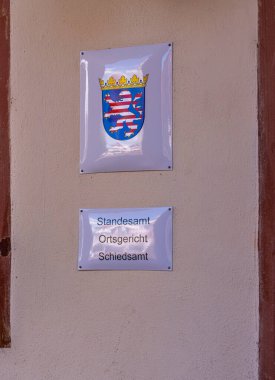 Belediyenin ve sicil dairesinin girişinde silah ve bilgi tabelaları, Seligenstadt, Hesse, Almanya