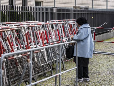 Kadın polis bariyerlerinin önünde duruyor, Berlin, Almanya