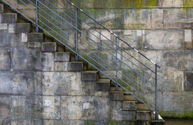 Berlin Şehri Temizlik Servisi 'nin turuncu çöp sepeti gri bir duvarın önünde, Spree nehir kıyısı hükümet bölgesinde, Berlin, Almanya
