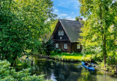 Tourism in Brandenburg, landscape with flowing waters, houses, kayaks, and forest area in the Spreewald in Lbbenau and Lehde, Brandenburg, Germany