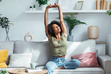 Evdeki koçta dinlenirken esneyen güzel bir kadının fotoğrafı.. 