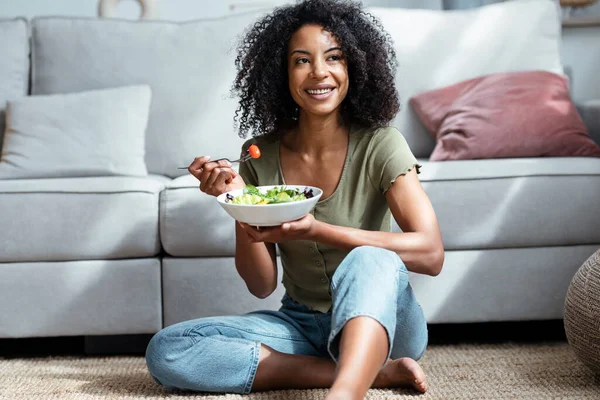 美しいです女性のショット食べる健康的なサラダながら座っていますソファに家 — ストック写真
