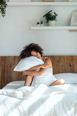 Yorgun bir kadının evde yataktan çıkmak istemediği için bir süre yastığa sarılmasından..