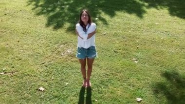 Güzel genç bir kadının parkta yoga ve meditasyon yaptığı bir video..