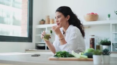 Evdeki mutfakta meyve suyu içerken yan bakan güzel bir kadının videosu..