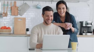 Güzel çiftin evdeki mutfakta kahvaltı yaparken dizüstü bilgisayarlarını kullandıkları bir video..