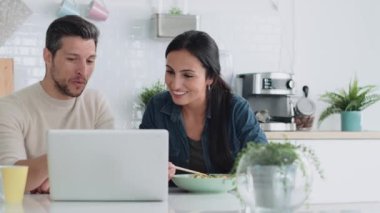 Güzel bir çiftin evde yemek çubuklarıyla yemek yerken dizüstü bilgisayarlarını kullandıkları bir video..