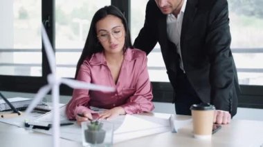 Ofisteki yeni tasarım işlerinden bahsederken planlarla çalışan akıllı mimarların videosu..