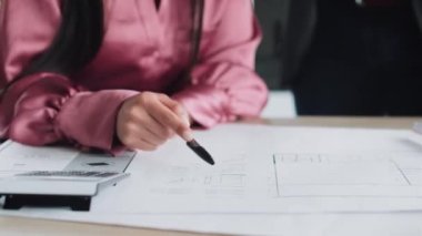 Ofisteki yeni tasarım işlerinden bahsederken planlarla çalışan akıllı mimarların yakın plan görüntüleri..
