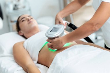 Kozmetik uzmanı iğnesi, bu prosedürü güzellik merkezinde genç ve güzel bir kadının derisinin ultrasonik olarak temizlenmesi yapar..