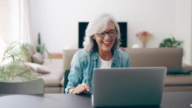 Video of happy grandmother speaking on videocall with her granddaughter using laptop at home.