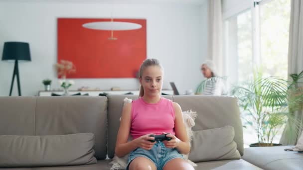 Video Cute Granddaughter Playing Video Games Concentrating Sofa Home — Vídeo de stock