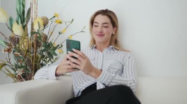 Video of beautiful woman using her mobile phone in the waiting room