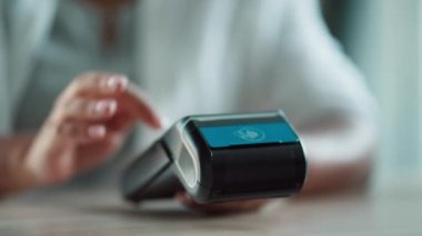 Video of female customer using her credit card to make payment with electronic reader in a shop.