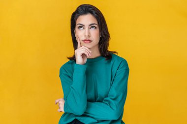 Güzel genç bir kadının portresi. Sarıda izole edilmiş kıyafetlerini düşünüyor. 
