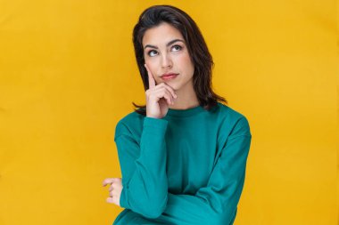 Güzel genç bir kadının portresi. Sarıda izole edilmiş kıyafetlerini düşünüyor. 