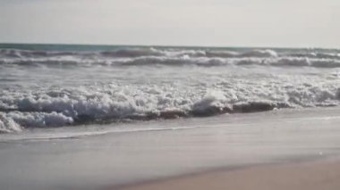 Soğuk bir kışın kumsaldaki mavi deniz dalgalarının videosu..