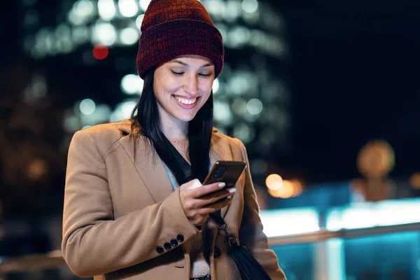 Geceleri Genç Güzel Bir Kadının Cep Telefonunu Kullanırken Çekilmiş — Stok fotoğraf