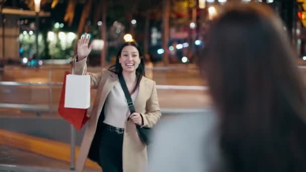 夜に路上で抱き合っている二人の友人の幸せな出会いのビデオ — ストック動画