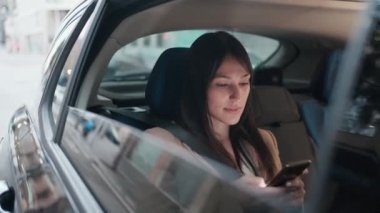 Arabasında cep telefonuyla mesaj gönderen güzel bir genç kadının videosu..