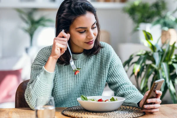 Shot Beautiful Young Woman Eating Bowl Salad While Usingh Her — Stock Photo, Image