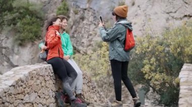 Dağ ormanlarındaki bir köprüde akıllı telefonla fotoğraf çeken sevimli bir ailenin videosu.
