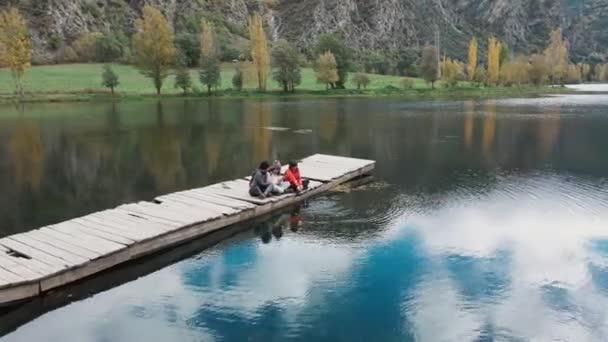 Видео Красивой Семьи Смотрящей Горизонт Сидящей Пирсе Озере — стоковое видео