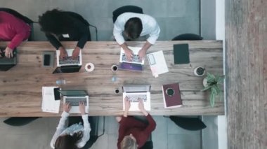 Birlikte çalışan bir grup iş adamının laptoplarla birlikte çalıştığı hava görüntüsü.