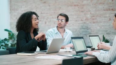 Bir iş yerinde konuşurken dizüstü bilgisayarlarla birlikte çalışan iş adamlarının videosu.
