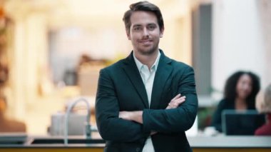 Takım elbiseli genç ve zeki bir işadamının birlikte çalışırken kameraya baktığı bir video.
