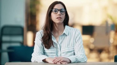 Genç ve güzel bir iş kadınının modern bir ofiste video görüşmesi yaparken dinleyip razı olduğu bir video.