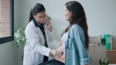 Kadın jinekoloğun klinikteki hamile hastasının kalp atışlarını kontrol ederken çekilmiş videosu..