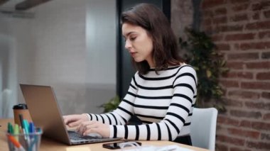 Modern bir ofisin planlarını çalışırken dizüstü bilgisayarla çalışan mimar kadının videosu..