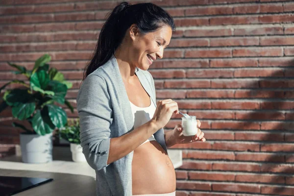 Shot Beautiful Cheerful Pregnant Woman Braces Eating Yogurt Kitchen Home — Stock Photo, Image
