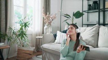 Motive olmuş genç bir kadının evinde dans ederken akıllı telefonuyla müzik dinlediği bir video..