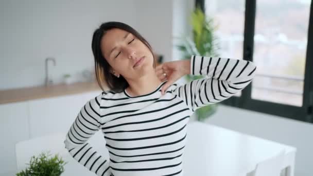 美丽的年轻女子背痛在家厨房里做伸展运动的录像 — 图库视频影像